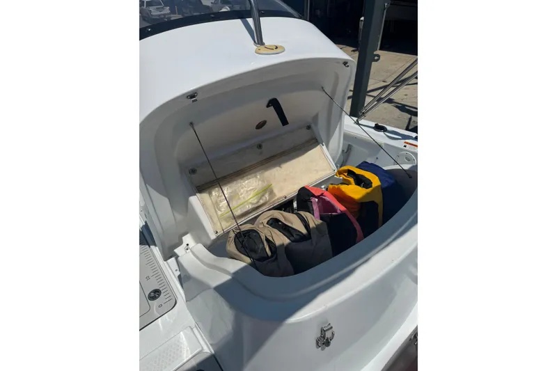 Slide: The Image of Open storage compartment on a 2004 Triumph 210 CC boat with bags inside. - 15