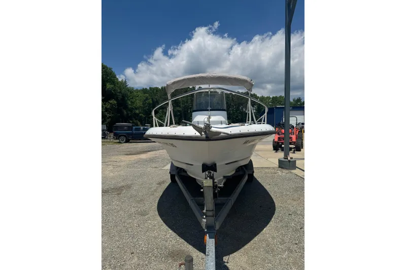 Slide: The Image of 2004 Triumph 210 CC boat on trailer under a clear blue sky. - 9