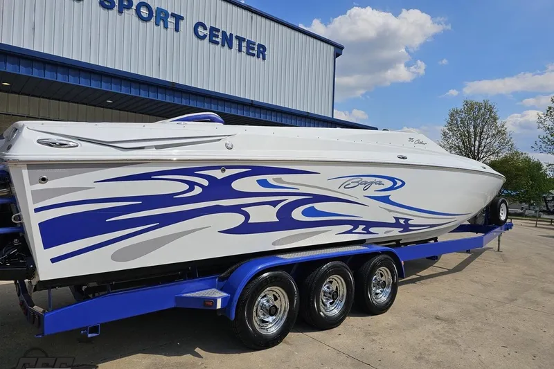 Slide: The Image of 2006 Baja 35 Outlaw speedboat with blue graphics on a trailer outside a sport center. - 11