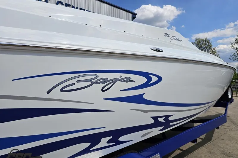 Slide: The Image of 2006 Baja 35 Outlaw boat with sleek blue graphics on a trailer. - 12