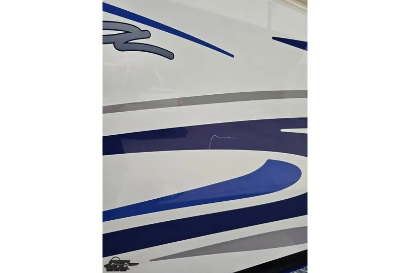 Slide: The Image of 2006 Baja 35 Outlaw boat with blue and gray graphics on white hull. - 23