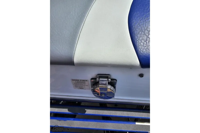Slide: The Image of 2006 Baja 35 Outlaw boat seat detail with shore power warning label. - 29