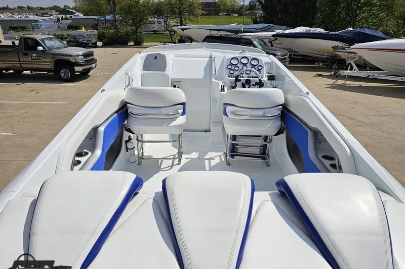 Slide: The Image of 2006 Baja 35 Outlaw boat interior with white and blue seating, parked outdoors. - 34
