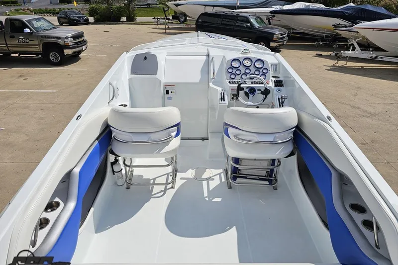Slide: The Image of 2006 Baja 35 Outlaw boat interior with white and blue seating, dashboard, and steering wheel. - 35
