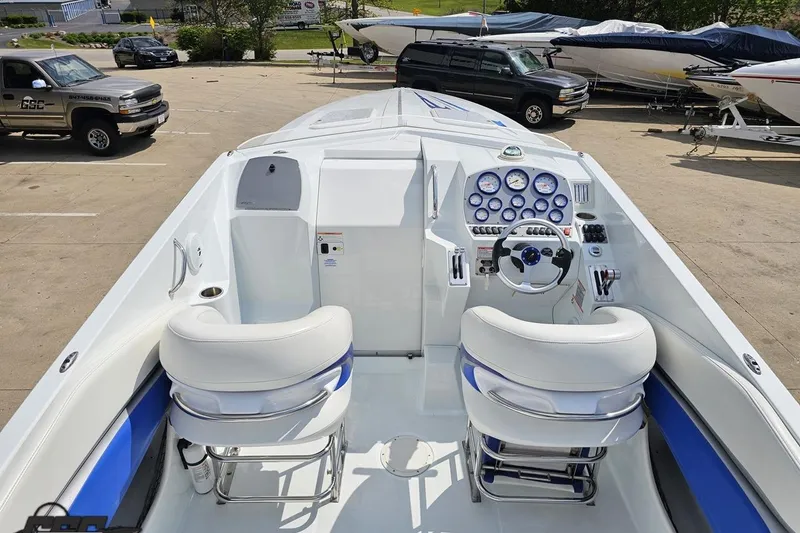 Slide: The Image of 2006 Baja 35 Outlaw boat cockpit with white and blue seating, steering wheel, and gauges. - 36