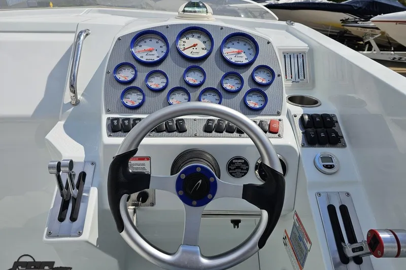 Slide: The Image of Dashboard of a 2006 Baja 35 Outlaw boat with gauges and steering wheel. - 48