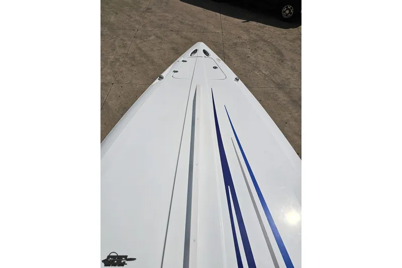 Slide: The Image of 2006 Baja 35 Outlaw boat deck with blue stripes on concrete surface. - 56