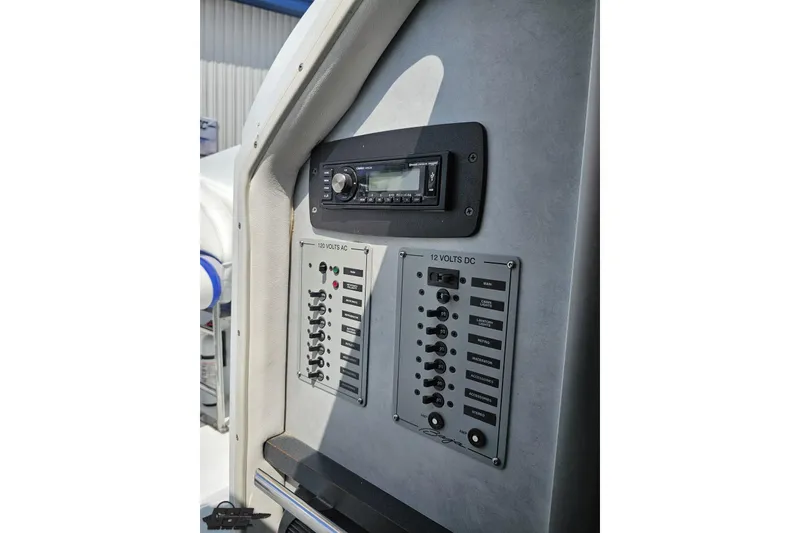 Slide: The Image of 2006 Baja 35 Outlaw boat control panel with stereo and electrical switches. - 65