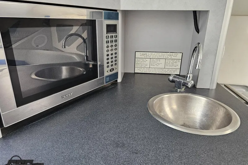 Slide: The Image of Microwave and sink in 2006 Baja 35 Outlaw boat kitchen area. - 66