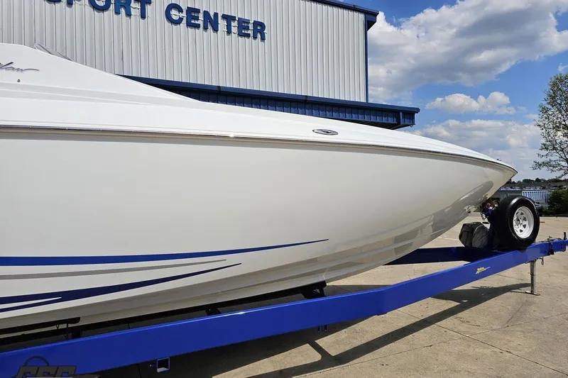 Slide: The Image of 2006 Baja 35 Outlaw boat on trailer at a sport center, under blue sky. - 7