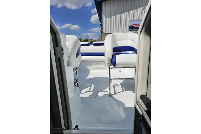 Slide: The Image of 2006 Baja 35 Outlaw boat interior with white and blue seating under a sunny sky. - 76