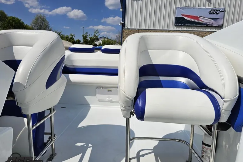 Slide: The Image of 2006 Baja 35 Outlaw boat interior with white and blue seating under a clear sky. - 77