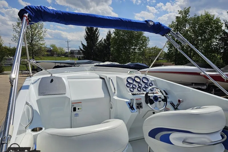 Slide: The Image of 2006 Baja 35 Outlaw boat cockpit with steering wheel and gauges under blue sky. - 88