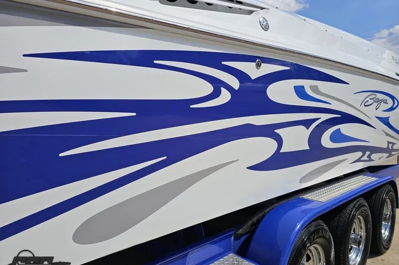 Slide: The Image of 2006 Baja 35 Outlaw boat with blue and white graphic design on the side. - 90