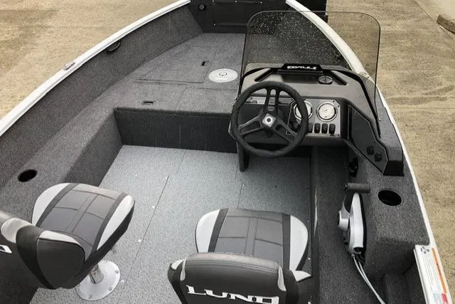 Slide: The Image of 2026 Lund 1650 Rebel XL SS boat interior with steering console and seating. - 2