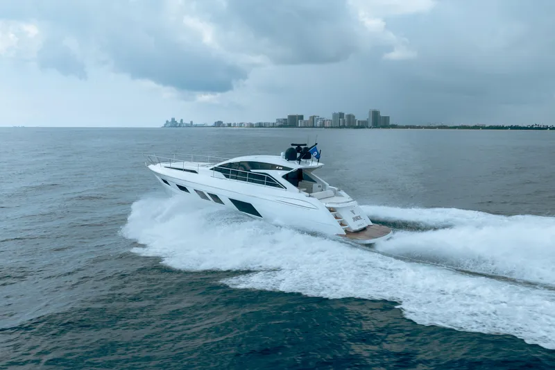 Slide: The Image of 2019 Filippetti S55 yacht cruising on open water near a city skyline. - 8