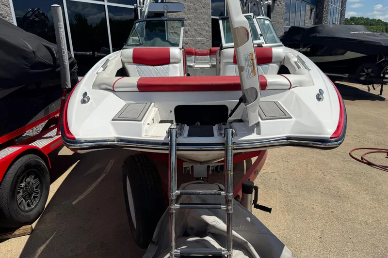 Slide: The Image of 2013 MasterCraft X-45 boat with red and white interior, parked outdoors. - 2
