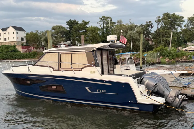 The Image of 2022 Jeanneau NC Weekender 1095 boat docked, featuring sleek design and dual outboard engines. - 0