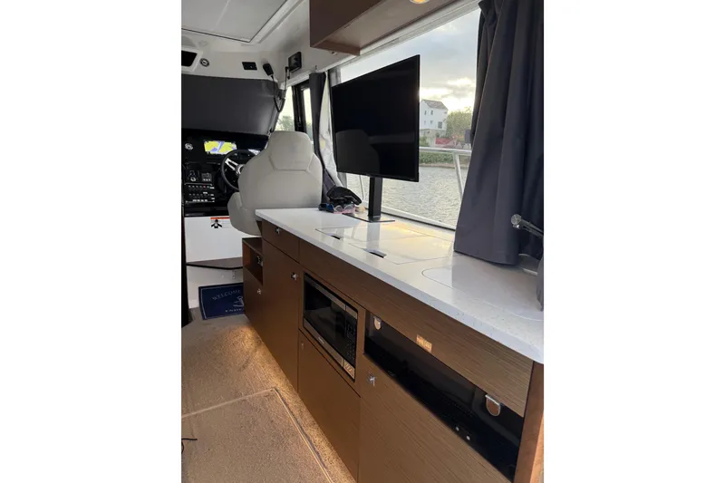 Slide: The Image of Interior of 2022 Jeanneau NC Weekender 1095 with modern kitchen and helm station. - 11