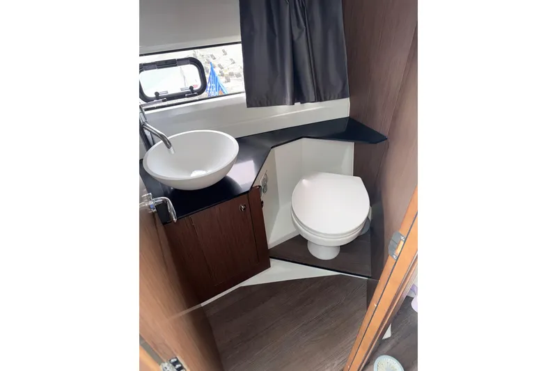 Slide: The Image of Bathroom interior of 2022 Jeanneau NC Weekender 1095 with sink and toilet. - 12