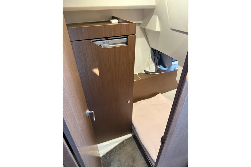 Slide: The Image of Interior cabin of 2022 Jeanneau NC Weekender 1095 with wooden cabinetry and cozy bedding. - 7