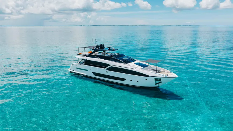 Slide: The Image of Luxurious 2020 Riva 90 Argo yacht cruising on clear turquoise waters under a blue sky. - 2