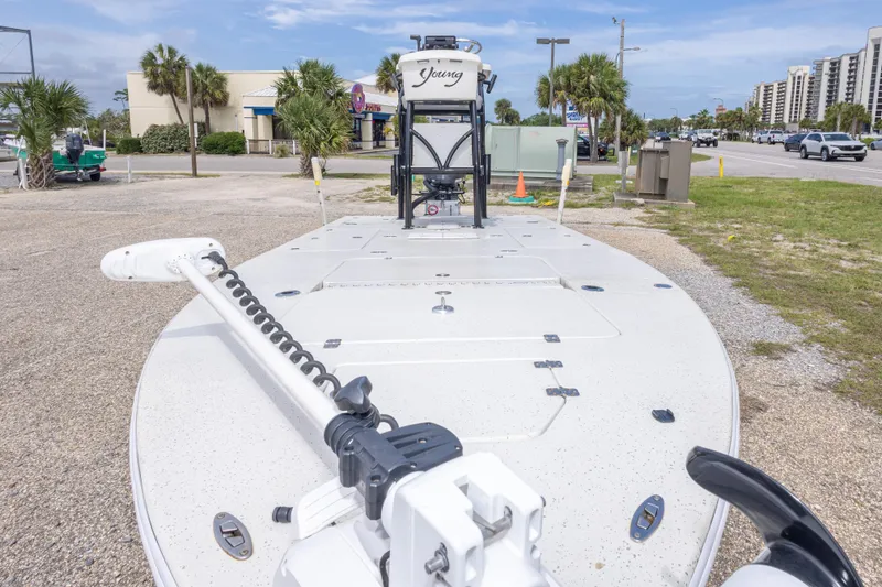 Slide: The Image of 2012 Young GulfShore 20 boat parked on gravel, with palm trees and buildings in background. - 21