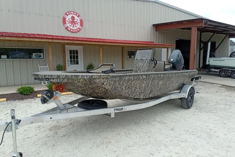 Slide: The Image of Camouflage-patterned 2026 Thor 1900 Lake Hammer boat on trailer outside First Mates building. - 30