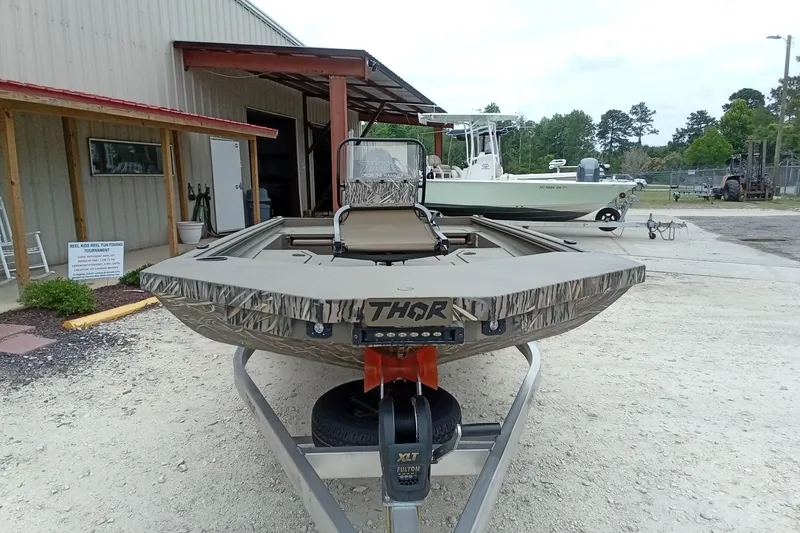 Slide: The Image of 2026 Thor 1900 Lake Hammer boat on trailer outside a building. - 31