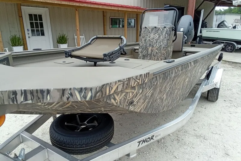 Slide: The Image of Camouflage-patterned Thor 1900 Lake Hammer boat on trailer, 2026 model, parked outdoors. - 32