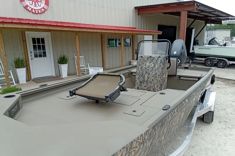 Slide: The Image of 2026 Thor 1900 Lake Hammer boat with camouflage design, parked outside a building. - 33
