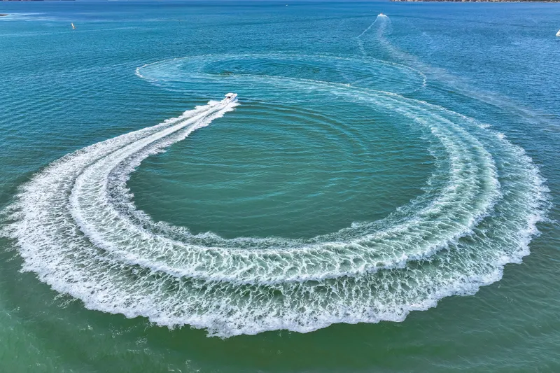 Slide: The Image of Aerial view of 2025 Jupiter 34 HFS boat creating circular wake patterns. - 44