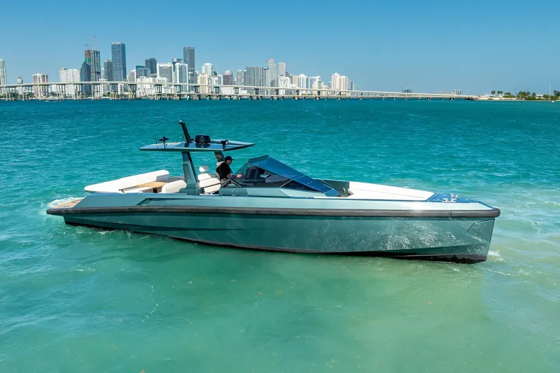 Slide: The Image of 2021 Wally 48 Wally Tender yacht cruising near city skyline on turquoise waters. - 7