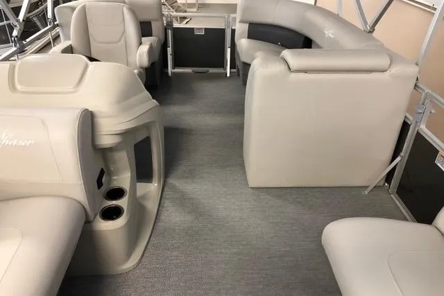 Slide: The Image of 2024 SunChaser Vista 18 LR pontoon boat interior with beige seating and cup holders. - 1