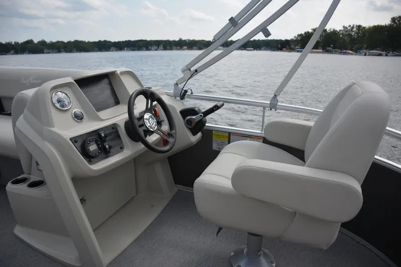 Slide: The Image of Manufacturer Provided Image: 2024 SunChaser Vista 18 LR boat interior with steering console and captain's chair on a lake. - 11