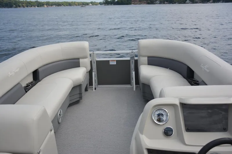 Slide: The Image of Manufacturer Provided Image: 2024 SunChaser Vista 18 LR pontoon boat interior with comfortable seating on a lake. - 9
