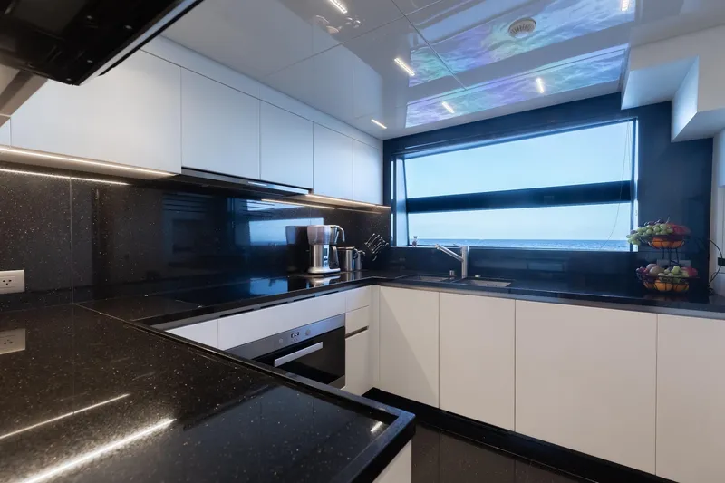 Slide: The Image of Modern kitchen interior on 2020 Sanlorenzo SLA120A yacht, featuring sleek black countertops and ocean view. - 20