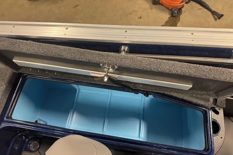 Slide: The Image of Open storage compartment in a 2026 Nitro ZV21 Pro boat, featuring a blue interior. - 9