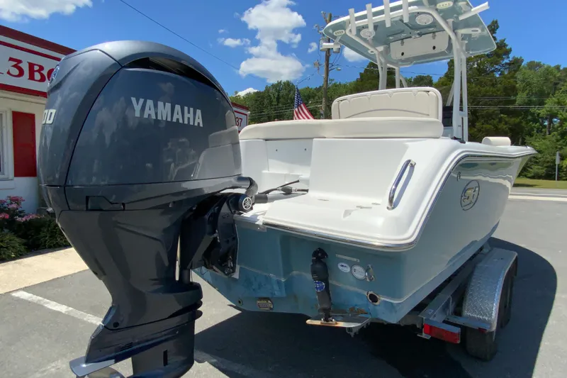 Slide: The Image of 2024 Sea Hunt Ultra 234 boat with Yamaha engine, parked on a trailer under a clear sky. - 10