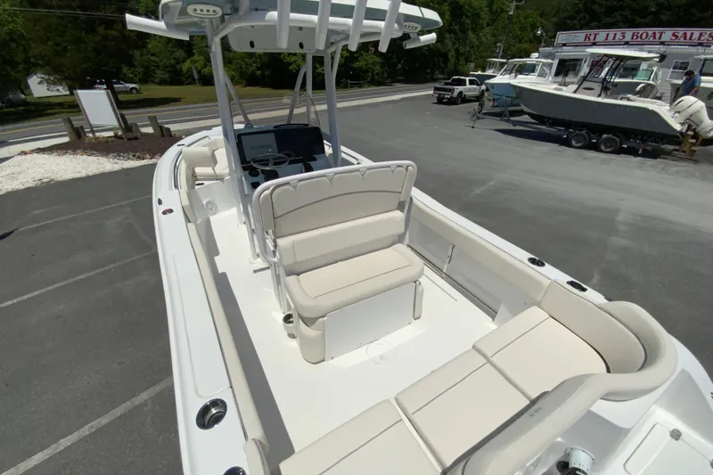 Slide: The Image of 2024 Sea Hunt Ultra 234 boat with spacious seating and modern design at a dealership. - 11