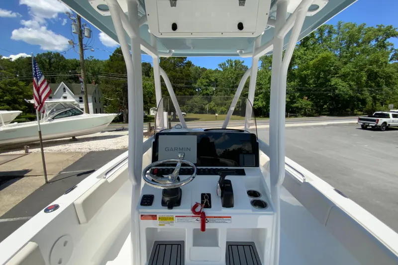 Slide: The Image of 2024 Sea Hunt Ultra 234 boat console with Garmin navigation, parked outdoors. - 14