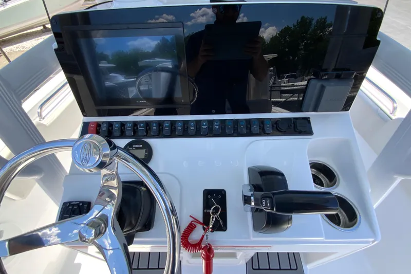 Slide: The Image of 2024 Sea Hunt Ultra 234 helm with steering wheel, controls, and display screen. - 15