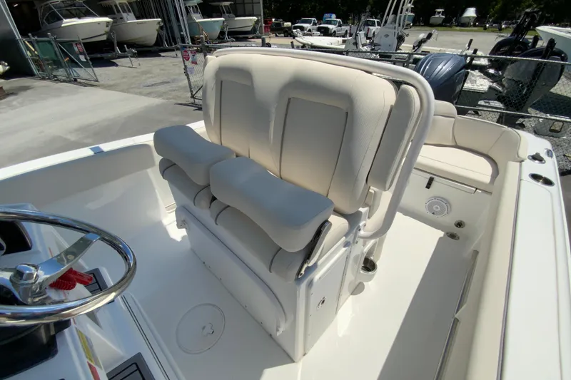 Slide: The Image of 2024 Sea Hunt Ultra 234 boat interior with cushioned seating and steering wheel. - 17
