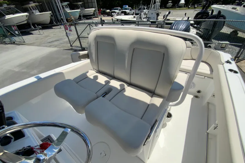 Slide: The Image of 2024 Sea Hunt Ultra 234 boat interior with comfortable seating and steering wheel. - 18