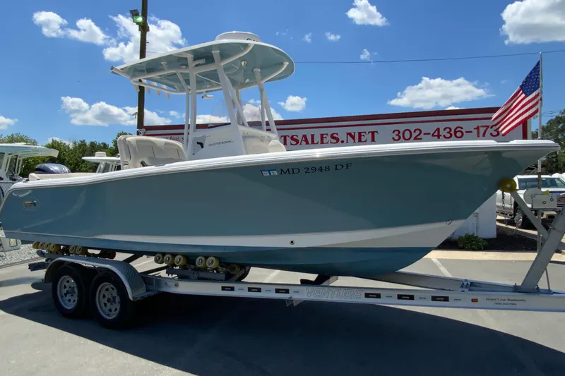 Slide: The Image of 2024 Sea Hunt Ultra 234 boat on trailer, displayed outdoors under blue sky. - 2