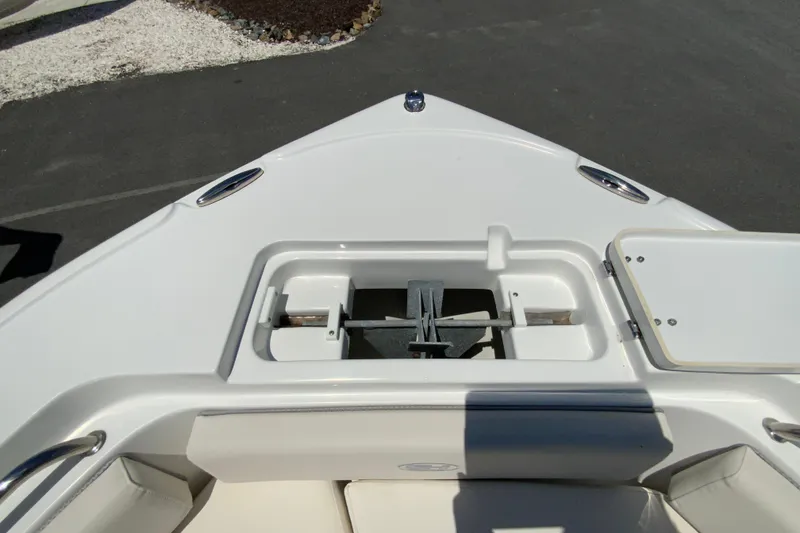 Slide: The Image of 2024 Sea Hunt Ultra 234 boat anchor compartment, open lid, white interior. - 25