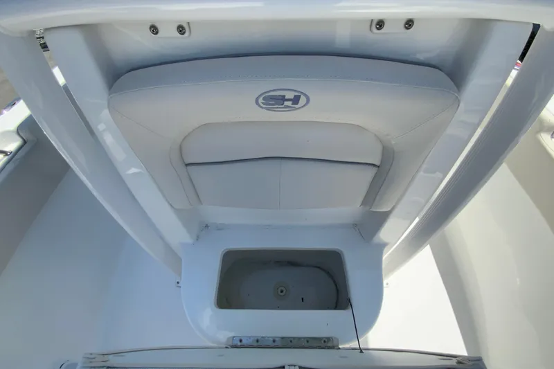 Slide: The Image of 2024 Sea Hunt Ultra 234 boat seat and storage compartment, featuring sleek white design. - 27