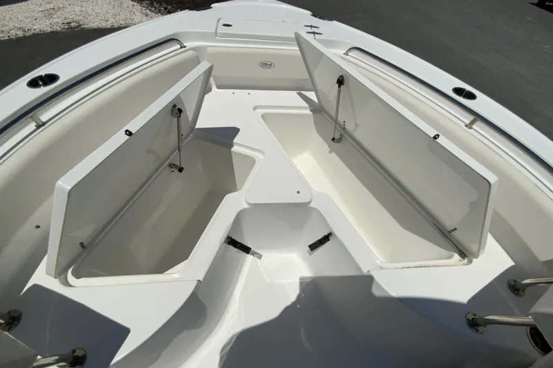Slide: The Image of 2024 Sea Hunt Ultra 234 boat with open storage compartments on deck. - 29
