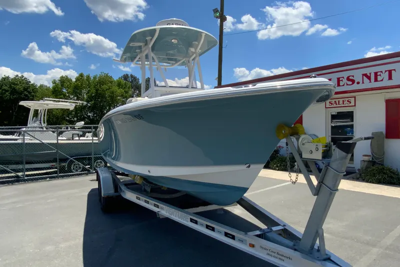 Slide: The Image of 2024 Sea Hunt Ultra 234 boat on trailer under blue sky. - 3