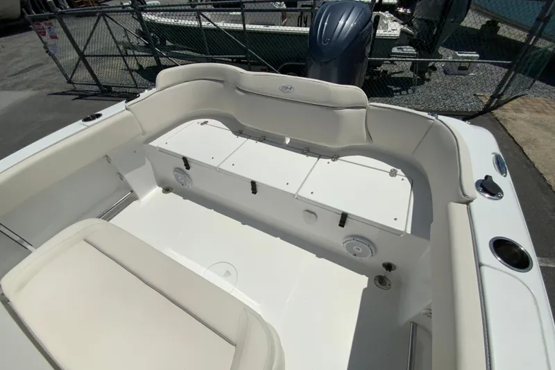 Slide: The Image of 2024 Sea Hunt Ultra 234 boat interior with cushioned seating and storage compartments. - 30